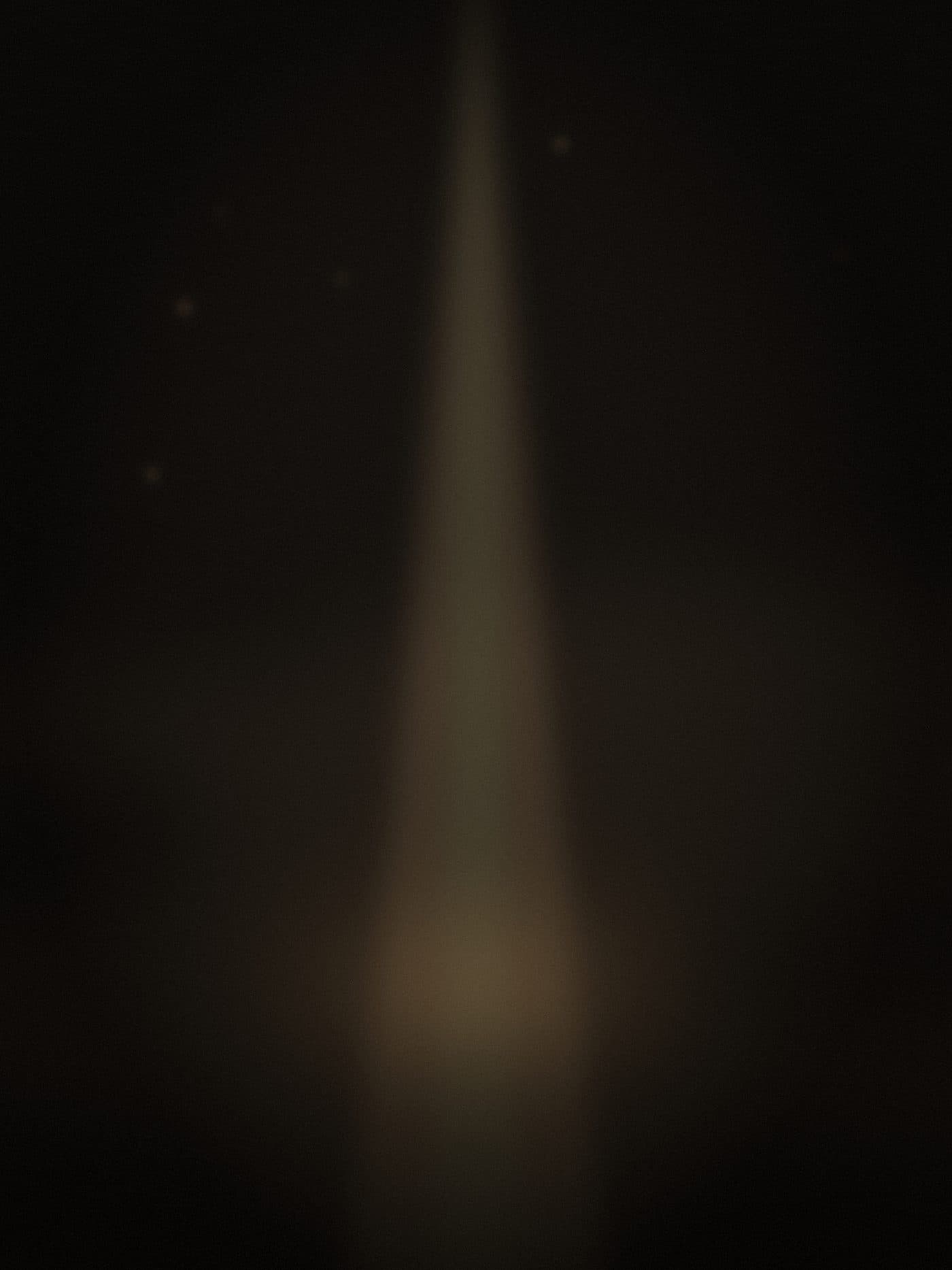 a single spotlight cone cutting through haze in a dark room