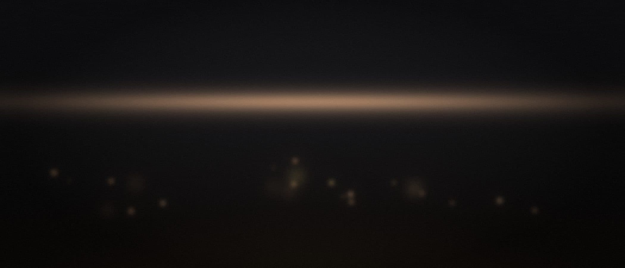 a dusk horizon over the bay with candlelight bokeh along a terrace edge